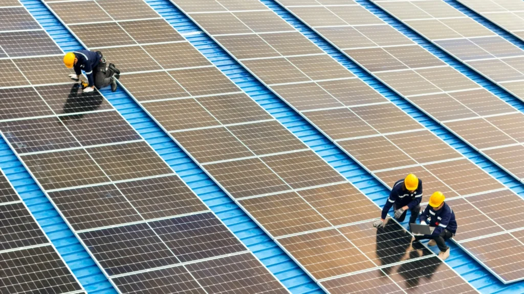 Plantas fotovoltaicas y sus paneles solares, inspeccionada por técnicos con casco de seguridad.