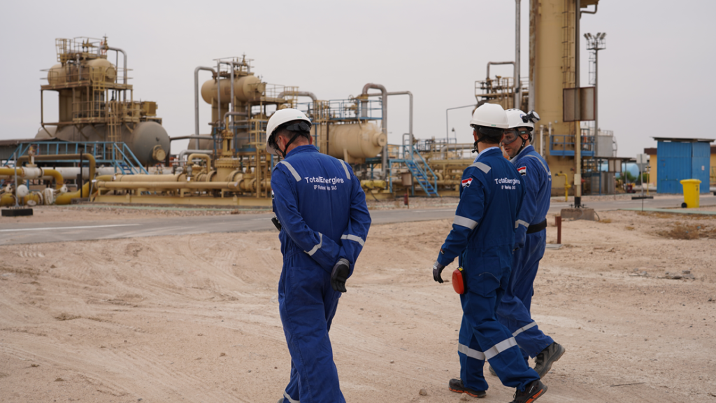 Ingenieros de TotalEnergies con uniforme azul y casco de seguridad recorren instalaciones energéticas en Irak como parte del Proyecto GGIP.