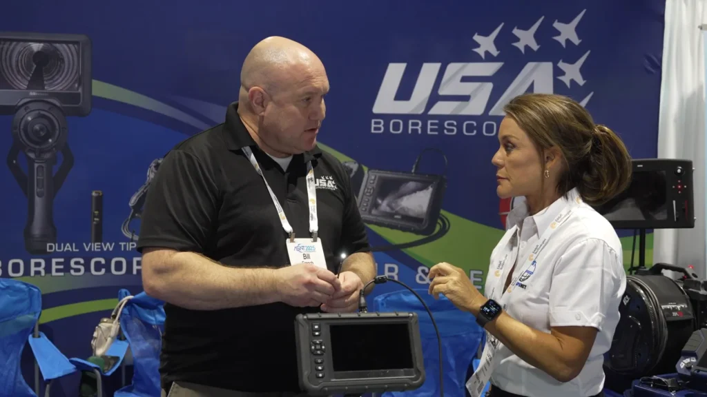 Bill French, especialista en ventas de USA Borescopes, demuestra el funcionamiento de un borescope durante una entrevista en el evento ASNT 2025.