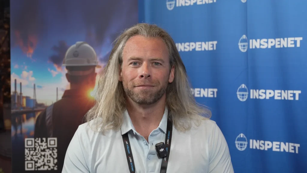 Joshua de Monbrun in front of the Inspenet stand during an interview about non-destructive testing.